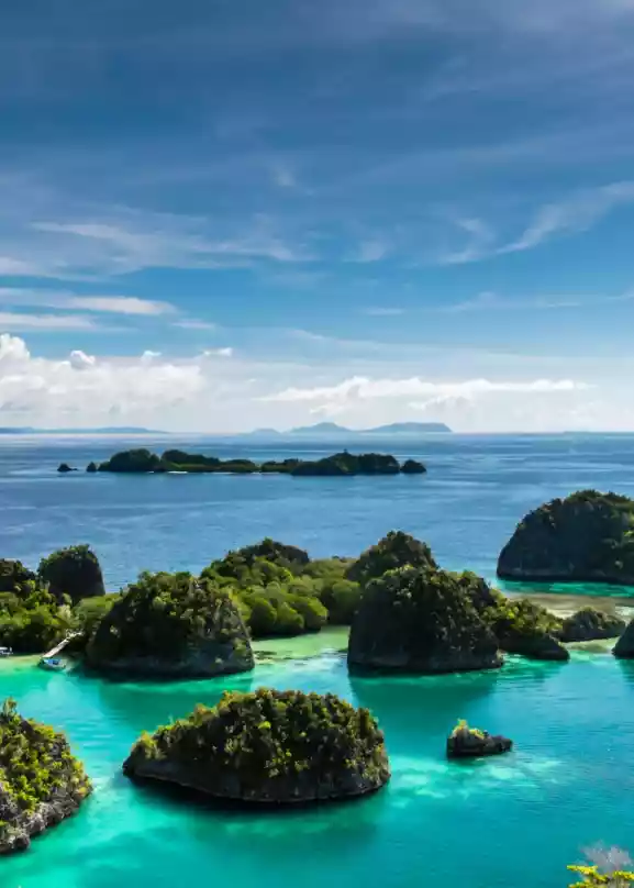 Oversiktsbilde av mange små øyer i Indonesia, omkranset av blått og asurblått vann.
