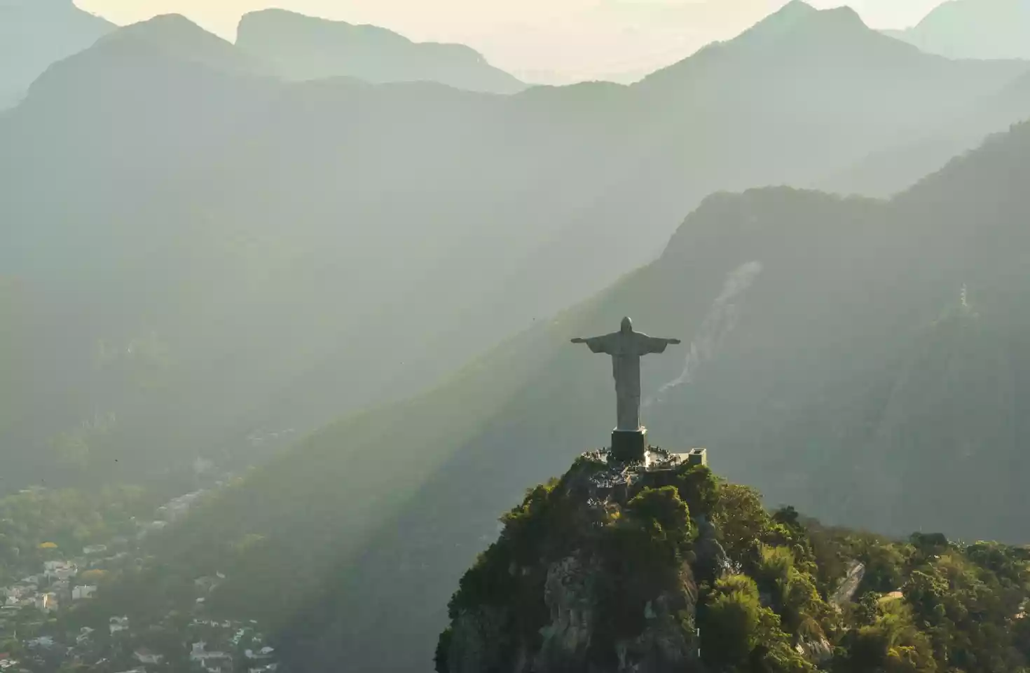 Kristus Frelseren i Rio de Janeiro, står på et fjell over Rio de Janeiro. Solstråler fra en lav sol skinner over de omkringliggende fjellene.