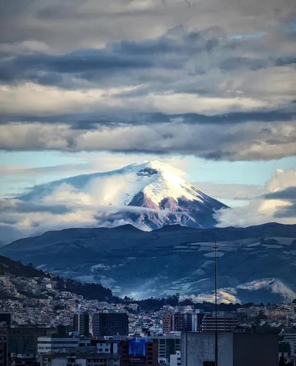 Overblikk over byen Quito, med snødekte fjell i bakgrunnen