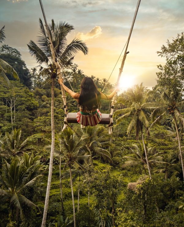 En dame på en huske i en tropisk jungel