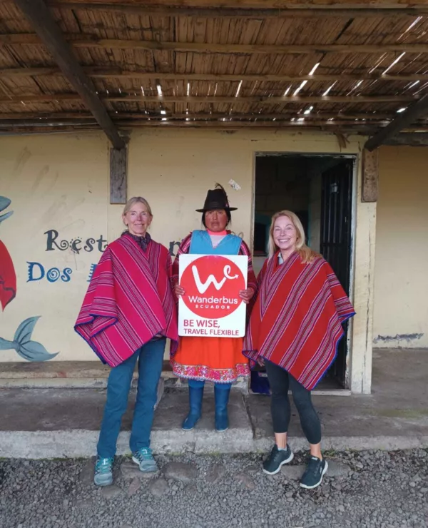 Glade reisende poserer med medlem fra stammefolk i Ecuador.