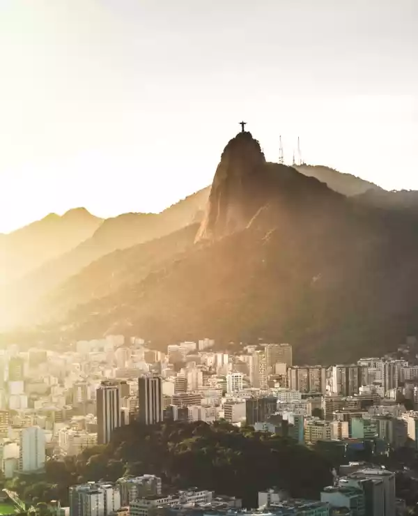 Rio de Janeiro ved morgengry, hvite blokker under fjellet med Kristusstatuen over seg.