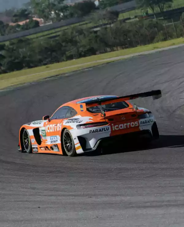 En oransje bil på Interlagos Circuit. Bilen er på vei inn i en sving på den asfalterte banen.